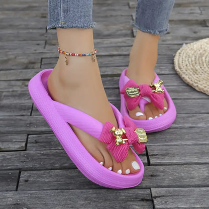 Anneliese – Plateau-Flip-Flops mit Schleife und goldenem Charm-Detail