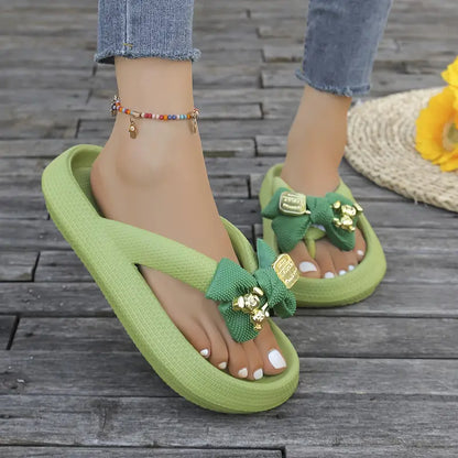 Anneliese – Plateau-Flip-Flops mit Schleife und goldenem Charm-Detail