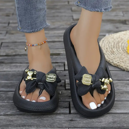 Anneliese – Plateau-Flip-Flops mit Schleife und goldenem Charm-Detail